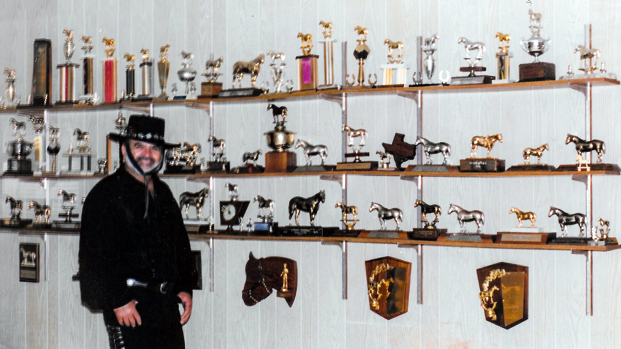 Al Ragusin in front of some of the many trophies and awards he has earned 